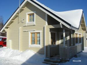 una pequeña casa con nieve en la parte delantera en Himos Villi Cottages, en Jämsä