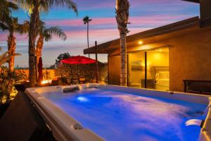 una bañera de hidromasaje frente a una casa con palmeras en Villa Callejon Del Sol Permit# 3082 en Palm Springs