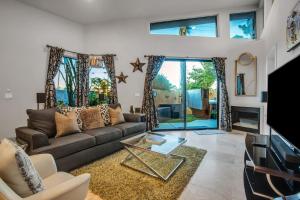 sala de estar con sofá y TV en Villa Callejon Del Sol Permit# 3082 en Palm Springs
