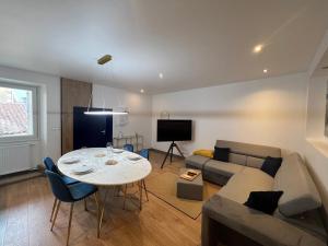ein Wohnzimmer mit einem Tisch und einem Sofa in der Unterkunft Les Arches - Superbe appartement en centre-ville in Poitiers