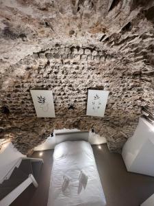 ein Schlafzimmer mit einem Bett in einer Steinmauer in der Unterkunft Les Arches - Superbe appartement en centre-ville in Poitiers