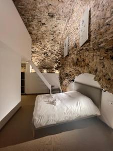 Bett in einem Zimmer mit einer Steinmauer in der Unterkunft Les Arches - Superbe appartement en centre-ville in Poitiers