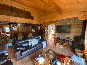 uma sala de estar com um sofá de couro e uma televisão em FINCA ALMAZARA em San Pablo