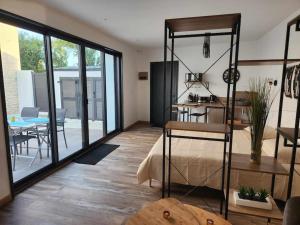 a room with a kitchen and a room with a table at Cocon pour 2 avec jacuzzi in Andilly-les-Marais