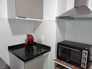 uma pequena cozinha com um balcão e um micro-ondas em Nuevo, apartamento completo, opción parking, en Cordón Soho em Montevidéu