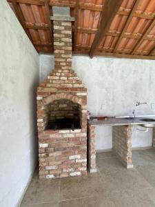 a brick oven in a room with a wooden ceiling at Fazenda Kidauana - Mendes in Mendes