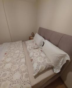 a bed with two pillows and a gray headboard at Maria's House in Thessaloniki