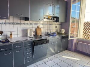 a kitchen with blue cabinets and a sink at Les chambres de Marielou in Aurillac