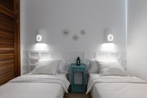 2 camas con sábanas blancas y mesita de noche azul en Villa Mo Luxury Heated Pool, en Playa Blanca 32 fotos más