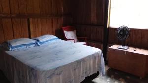 a bedroom with a bed and a fan and a window at Casa da Prosperidade in Presidente Figueiredo