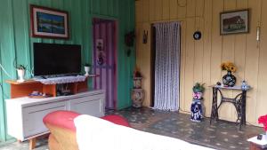 a living room with a tv and a couch at Casa da Prosperidade in Presidente Figueiredo