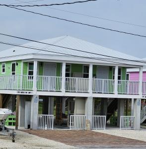 een groot huis met groen en roze bij Old Wooden Bridge Resort & Marina in Big Pine Key