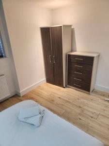 an empty room with a bed and a dresser at City Sparrow Apartment 2B in London