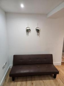 a brown couch in a room with a white wall at City Sparrow Apartment 2B in London