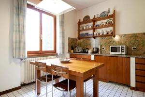 a kitchen with a wooden table and chairs at Villa Rosi in Lierna