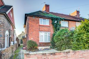 a brick house with ivy on the side of it at Pass the Keys Charming 2 Bedroom House Good Transport and Parking in London