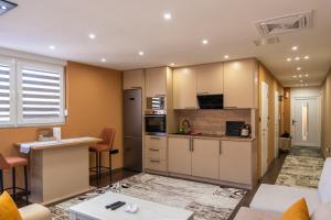 a large kitchen with white cabinets and a counter at Ema, Asja, Eda Apartments in Zenica