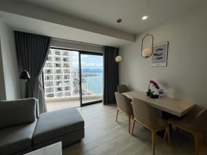 Una sala de estar con un sofá y una mesa con sillas. en HONEY MOON, en Nha Trang