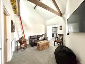 - un salon avec un canapé en cuir et une table dans l'établissement Apartment in Midsomer Norton High St, à Midsomer Norton