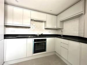 米德索莫諾頓的住宿－Modern Luxury Apartment in Midsomer Norton High St，白色的厨房配有白色橱柜和水槽