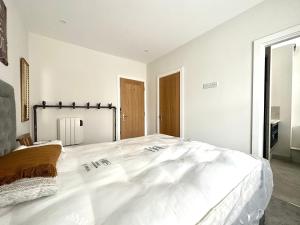 a white bedroom with a large white bed in it at Apartment in Midsomer Norton High St in Midsomer Norton