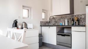 普瓦捷的住宿－Le Modernisme - Joli T3 lumineux pour 4 pers，小厨房配有白色橱柜和炉灶。