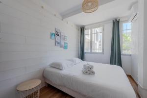 a bedroom with a white bed and a window at The boheme chic - 200 meter from the beach- in Canet-en-Roussillon