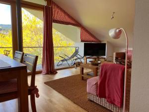 sala de estar con mesa de comedor y ventana grande en Bergzeit Ferienwohnungen en Oberstdorf