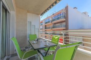 einen Tisch und Stühle auf einem Balkon mit einem Gebäude in der Unterkunft 004 - Club Náutico 001 - comfortHOLIDAYS in Santa Pola