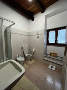 La salle de bains est pourvue d'une baignoire, de toilettes et d'un lavabo. dans l'établissement La Cürt Brandon, à Frassinetto
