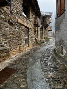 une ancienne ruelle en pierre avec un bâtiment en pierre dans l'établissement La Cürt Brandon, à Frassinetto