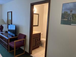 a bathroom with a desk and a chair and a mirror at The Hotel Pratt in Cooperstown