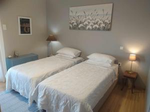 duas camas num quarto com duas lâmpadas e uma imagem na parede em Unique flat of refined luxury and splendid views. em Cavala