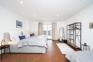- une chambre blanche avec 2 lits et une fenêtre dans l'établissement LaDolceVita - 100m2 Apartment in Zentraler Lage, à Olching