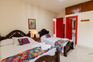 a bedroom with two beds and a red door at Hotel Casa Grande in Jardin