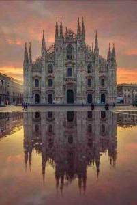 um edifício antigo com o seu reflexo na água em Il Torchietto, incanto nel cuore di Milano em Milão