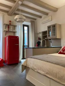 uma cozinha com um frigorífico vermelho num quarto em Il Torchietto, incanto nel cuore di Milano em Milão