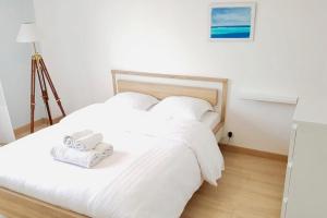 a white bed with two towels on top of it at The pleasant - 10 minutes from the center of Montpellier! in Montpellier