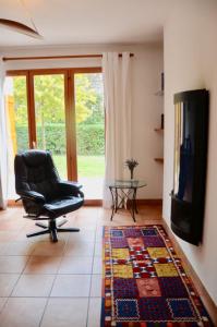a living room with a chair and a television at The pleasant - 10 minutes from the center of Montpellier! in Montpellier