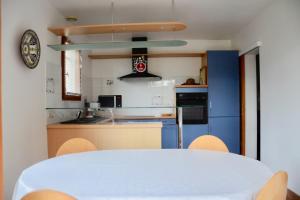 a kitchen with a white table and a blue cabinet at The pleasant - 10 minutes from the center of Montpellier! in Montpellier