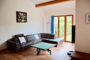 a living room with a leather couch and a table at The pleasant - 10 minutes from the center of Montpellier! in Montpellier