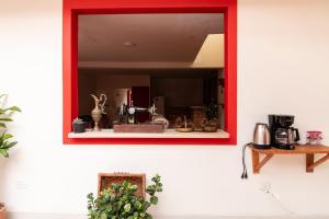 a mirror on a wall with a red frame at Hotel Casa Grande in Jardin