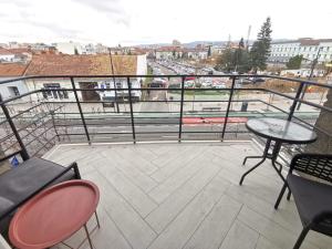 balcone con tavoli, sedie e vista sulla città di Urban Retreat Cluj a Cluj-Napoca