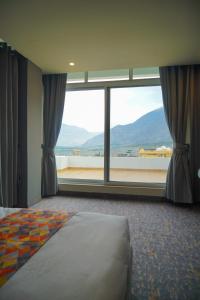a bedroom with a large window with a view at Destination Hotel Gilgit in Gilgit