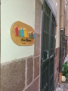 un panneau en bois sur le côté du bâtiment dans l'établissement Casa Eleonora, à Bosa