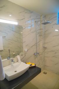 a white bathroom with a sink and a shower at Destination Hotel Gilgit in Gilgit