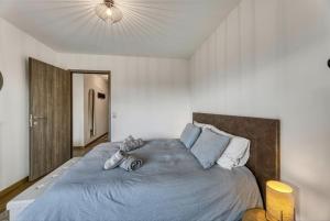 a bedroom with a large bed with a blue comforter at View Point Trésumvibes - Appartement cosy, proche lac & vielle ville in Annecy