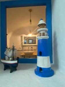un phare bleu et blanc devant un miroir dans l'établissement Casa Eleonora, à Bosa