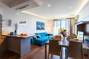 a kitchen and living room with a blue couch at BAMBOO PLAGE AP4220 by Riviera Holiday Homes in Nice