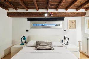 ein Schlafzimmer mit einem weißen Bett und einem Fenster in der Unterkunft iFlat Marvellous home near Via del Corso in Rom